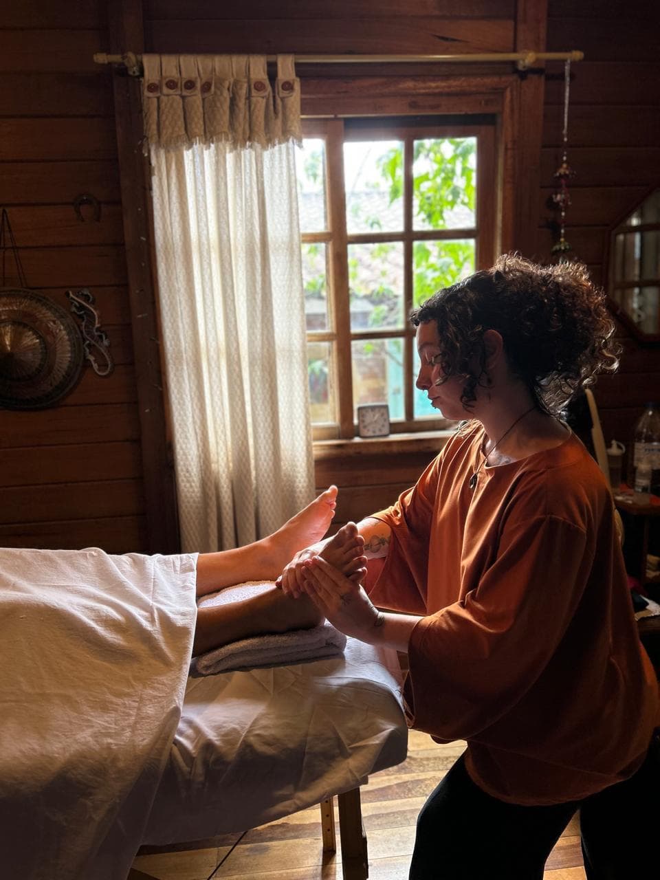 Laura durante um atendimento no estúdio, com luz de janela