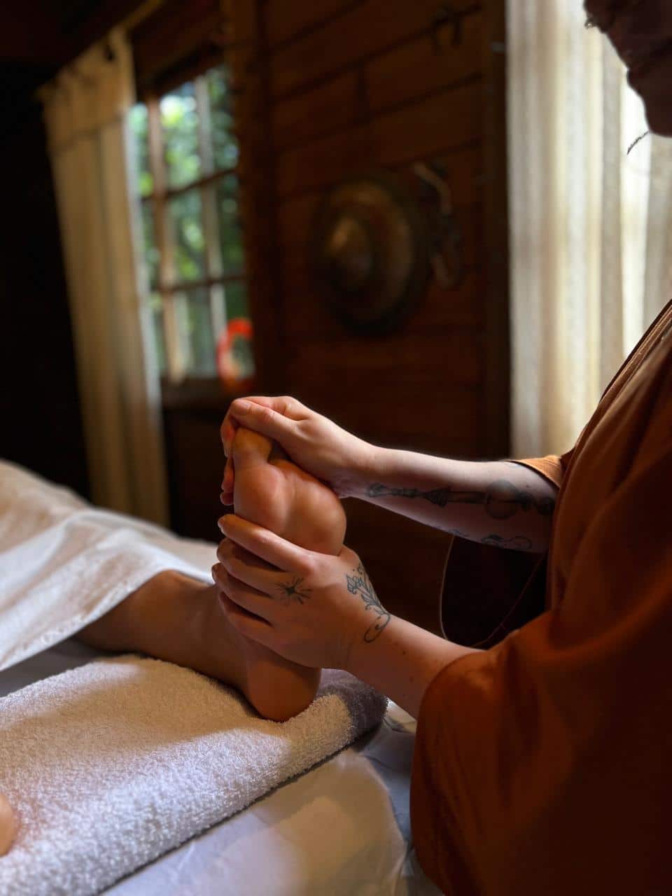 Detalhe das mãos de Laura durante uma massagem nos pés